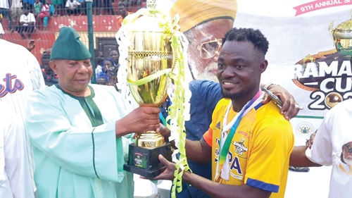Alhaji Abdul Latif (left), Director of Protocol at the Office of the National Chief Imam, presenting the trophy on behalf of Sheikh Usmanu Nuhu Sharubutu to the captain of the Ashaiman team