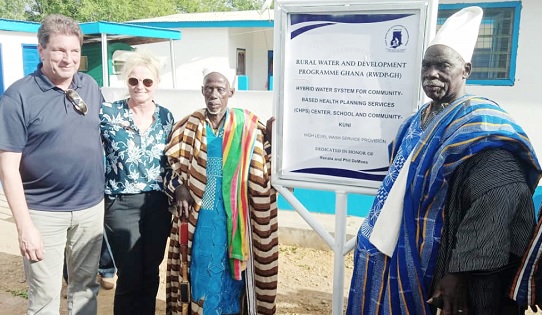 Officials of Water for West Africa being assisted by Naa Wumbei Ibrahim (middle), Chief of the Kuni community, to unveil the plaque of the facilities