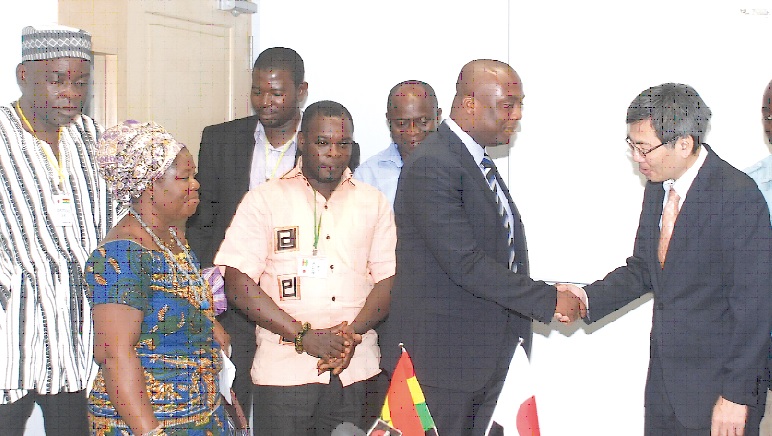 Mr Thomas Ampem-Nyarko (2nd right), the DCE, Asuogyaman District Assembly, in a handshake with Mr Naoto Nikai after signing the grant contract in Accra. Looking on are members of the assembly and  Nana Ohenewaa I (2nd left), Queenmother of Dodi-Asantekrom. 