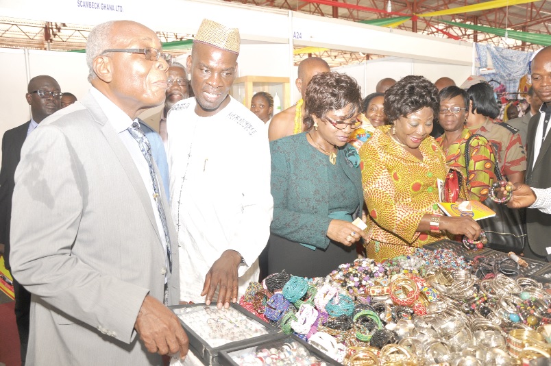 Mr Haruna Iddrisu (2nd left), Minister of Trade and Industry, explaining a point to Mr C.K. Dewornu (left), a member of the Council of State, while Mrs Adiku Heloo (4th left), Deputy Minister of Environment, Science & Natural Resources, and Madam Naomie Azaria Hounhoui (3rd left), Minister of Industry, Commerce & Small Enterprises of the Republic of Benin, take a look at some products on exhibition.