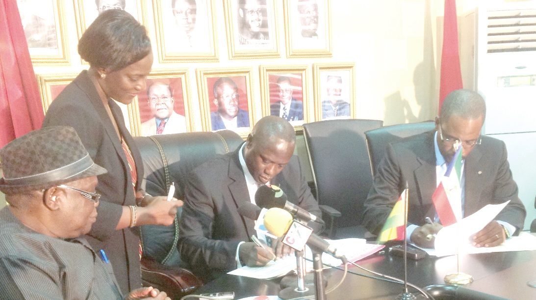 The Energy Minister, Mr Kofi Armah Buah (seated in the middle) and Mr Gabriel Obiang Lima (right) signing the amended cooperation agreement, while officials of the Ministry of Energy look on.