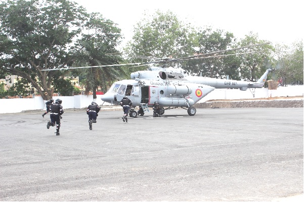 Some policemen demonstrating on how to use the Ghana Air Force Helicopter during a riot after the commissioning of the Ghana Police Helipad at a ceremony in Accra.