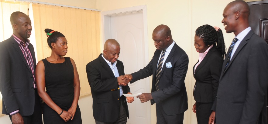 Mr Isaac Ofori Poku, MD, Vision 2007 (3rd left), receiving a cheque from Mr George Addai