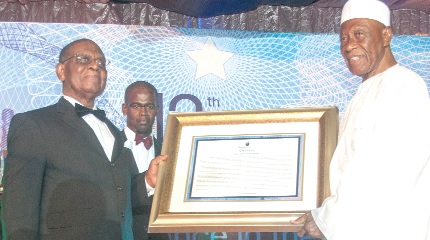 Mr J. S. Addo (left) receiving a citation from transport mogul, Alhaji Asuma Banda