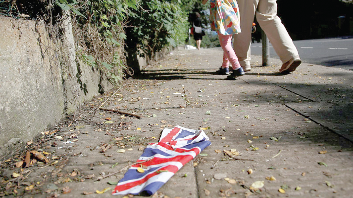 A British flag which was washed away by heavy rains the day before lies on the street in London