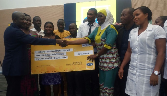 MTN CEO Ebenezer Twum-Asante presenting the dummy cheque to the beneficiaries