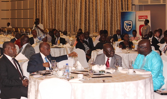 Mr Ken Ashigbey (right) and Mr Alhassan Andani (left), interacting with Mr Seth Terkper (2nd left), Finance Minister and Prof. Felix Asante (2nd right), Director, ISSER