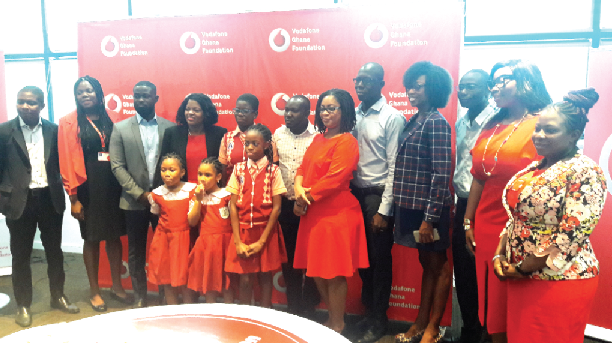 Yolanda Cuba (4th left) and Papa Kojo Sam (3rd left) with some schoolchildren and staff of Vodafone Ghana after the launch of the Instant School platform