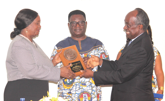 Dr Kofi Mbiah (middle), CEO, Ghana Shippers’ Authority, assisted by Prof. Samuel Date-Bah, presenting a plaque to the Chief Justice, Her Ladyship Justice Georgina Theodora Wood