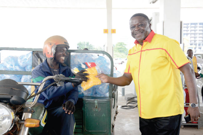 Mr Ebenezer Faulkner (right), Managing Director of Vivo  Energy Ghana, presenting a gift to customer