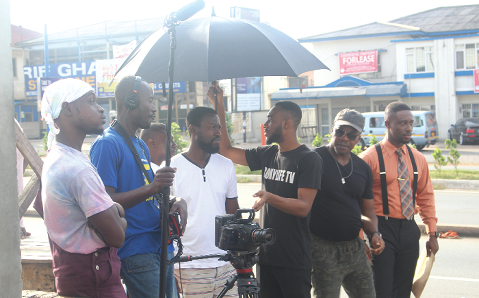 Fiifi Coleman (right), a character and Mr Kwame Boadi (2nd right), Executive Producer of Solutions, with other crew on set