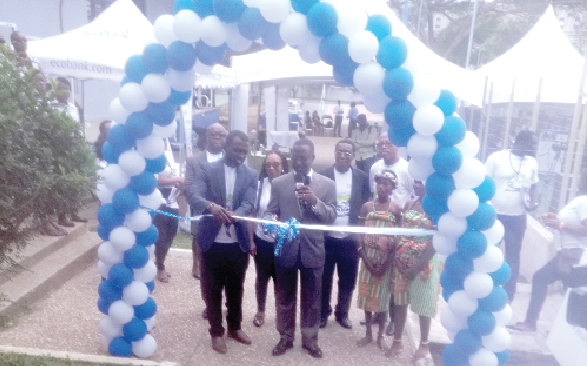  Mr Morgan Asiedu (with mic), Executive Director of Human Resource and Compliance at Ecobank, cutting the sod for the inauguration of the housing fair in Accra