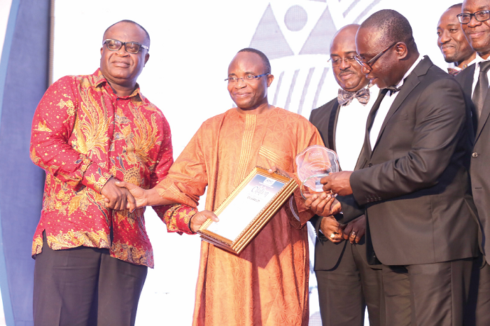 Mrs Josephine Okutu (left), Fellow of CIMG, presenting the Retail Outlet of the Year Award to Mr Godwin Avenogbor (2nd right), Director of Communication, Melcom Group of Companies.