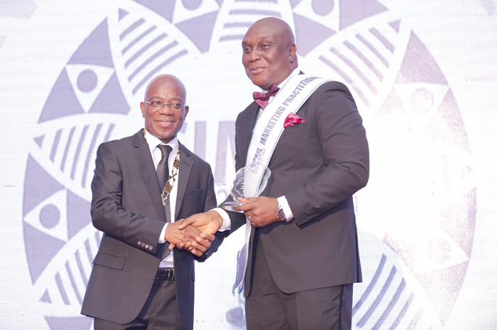 Mr Kojo Mattah (left), National President of CIMG, presenting a plaque to Mr Clifford Mettle, Director, Marketing and Alternate Channels, UNIBANK for being the marketing practitioner of the year 2016.