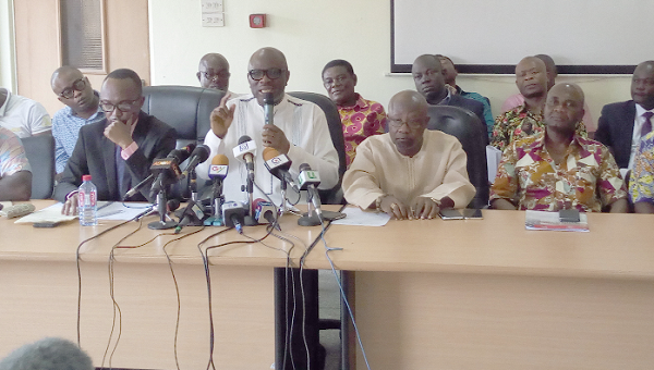 Dr Joseph Obeng (with microphone) addressing the media. Looking on are some dignitaries