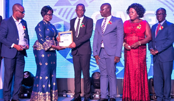 Mrs Comfort Owusu, Executive Director of Association of Rural Banks, presenting the award to the CEO Mr Siaka Ahmed Baba, while Issaka Rasheed, Head, Risk & Compliance(extreme left)Ernest Owusu Dapaa, Board Member (3rd from right)Mrs Georgina Addai, Board member and Mr Bernard Asamoah Boateng, Board Chairman (extreme right) look on admirably