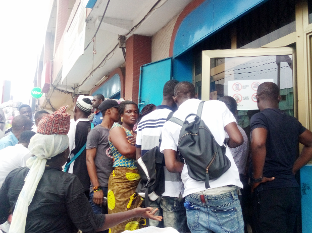 Some of the aggrieved customers in front of the Kantamanto branch of uniCredit Savings and Loans.Picture:ESTHER ADJEI