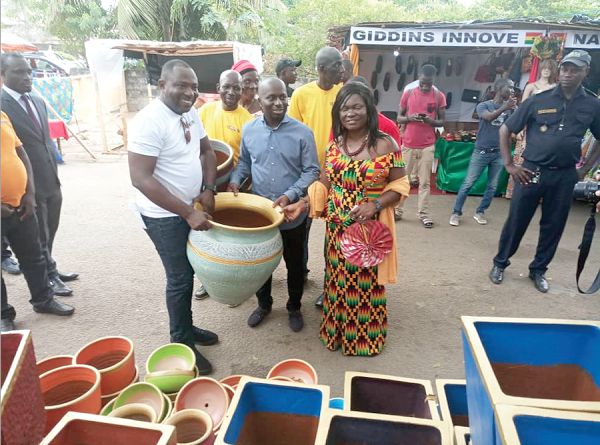 Mrs Agnes Gifty Adjei-Sam (right), Director, Marketing and Promotion at GEPA, presenting a pot to Mr Jean-Louis Moulot, the Mayor of Grand Bassam. Looking on is Nana Kwame Addo, CEO of Matamiss Pottery