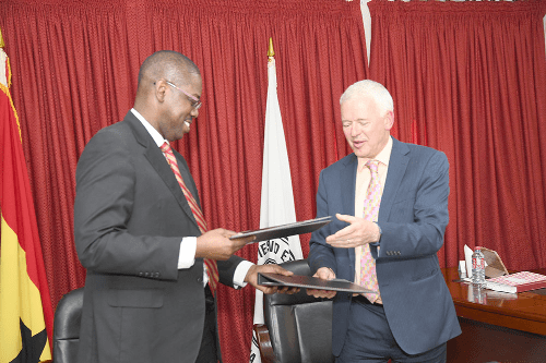 Rev Daniel Ogbarmey Tetteh (left and Mr Simon Culhane exchanging notes after signing the partnership agreement 