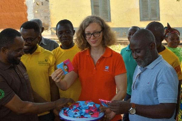 Mrs Merit Buama (middle), Programme Manager West Africa, Ritter Sport presenting some chocolate products to the Council Chairman of CAA, Mr Ismail Pomasi (left) and some CAA members during their visit. RIGHT: Mr Eliseus Opoku-Boamah and Mr Alfred Ritter signing the MoU.