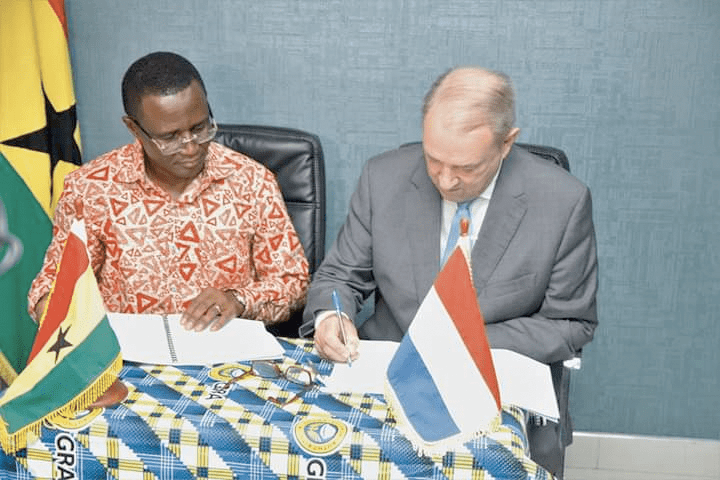 Mr Ron Strikker (right) signing the agreement while Mr Ammishaddai Owusu-Amoah looks on 