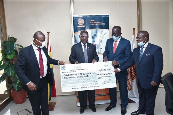  Mr George Otoo (2nd right) being assisted to present the dummy cheque to Mr Andrews Kwesi Frimpong (left) 