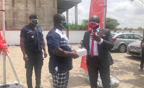  Mr Amaris Nana A. Perbi (right) presenting a box of nose masks to Rev. Solomon Kotey-Nikoi (left)