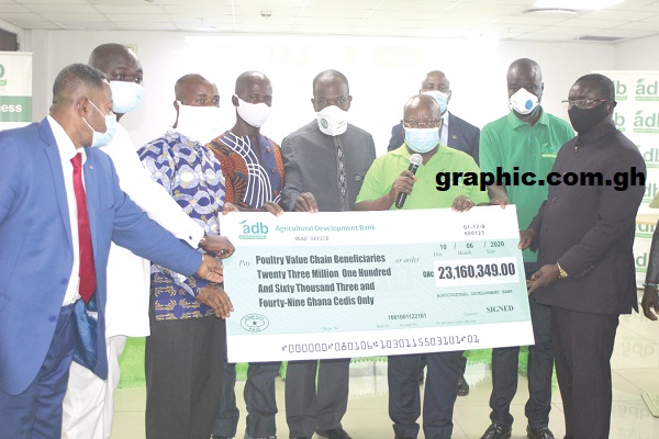 Dr John Kofi Mensah (3rd right) presenting the dummy cheque to Mr Daniel Akwah (3rd left), MD of ADF Farms, and other poultry value chain beneficiaries