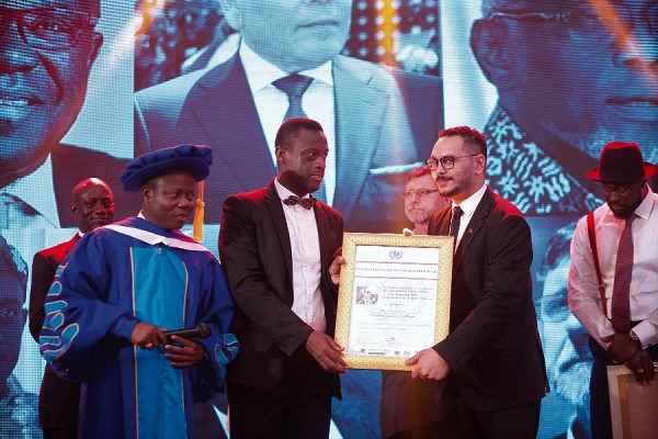 Mr Kwabena Okyere Darko-Mensah presenting a citation to Mr Emad Deraz (right), Executive Director, Gold Coast Refinery Ltd. Looking on is Archcardinal Prof. Eric Ofori Atta (left), Ghana Gold Expo Ambassador