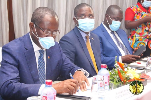 Mr Joseph Boahen Aidoo (left) signing the documents on the $1.3 billion cocoa loan. With him are other management members of COCOBOD