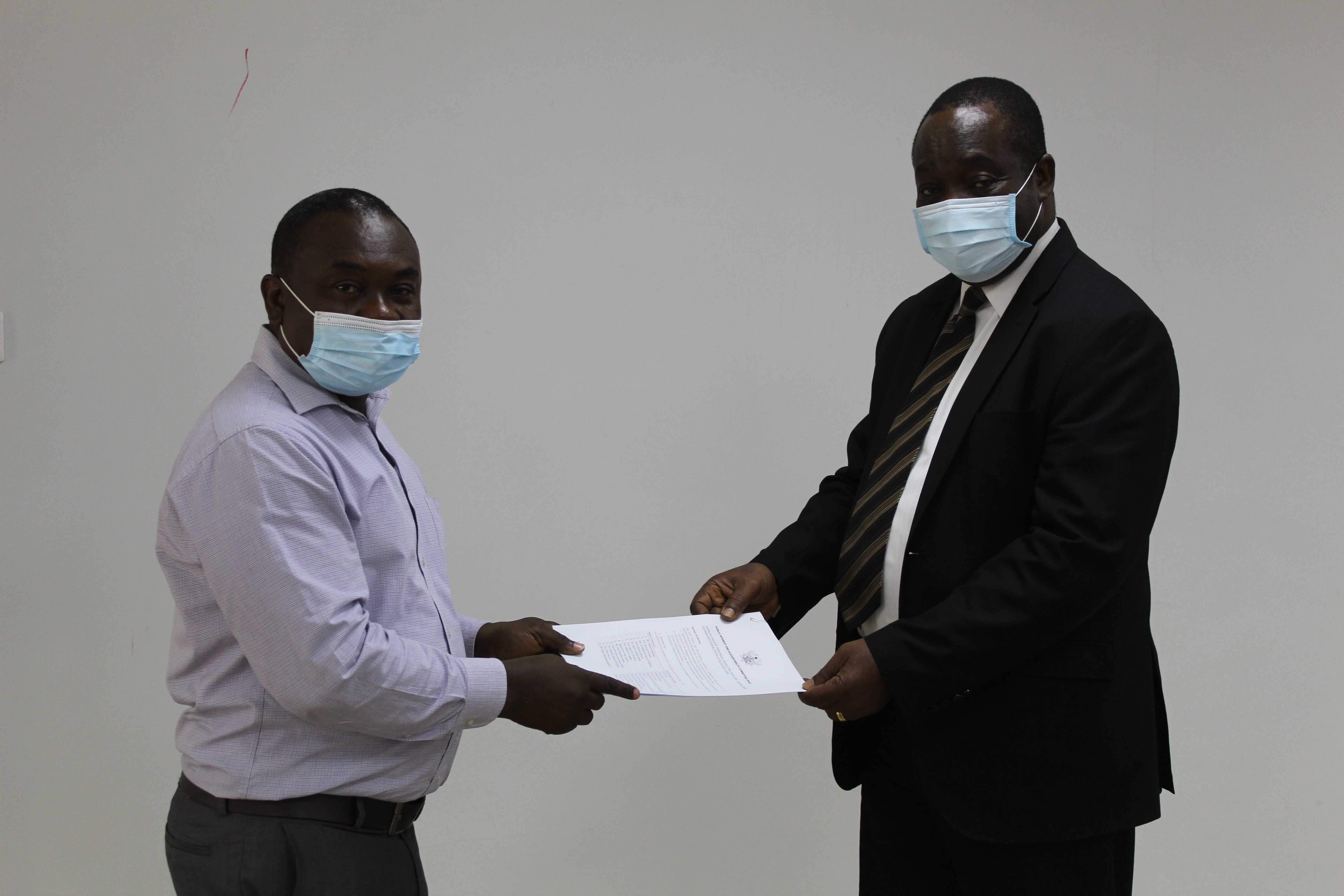 Prof Kwame Adom- Frimpong (right), Chairman of the Public Interest and Accountability Committee (PIAC) receiving the handing over notes from Mr Noble Wadzah, Outgone Chairman of PIAC.