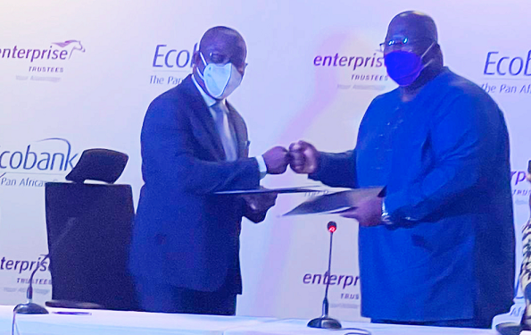 Mr Dan Sackey, (left) Managing Director of Ecobank Ghana exchanging documents with Mr Joseph Ampofo, Managing Director of Enterprise Trustees