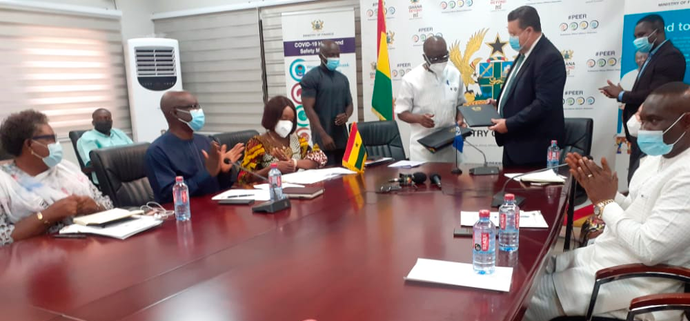   Mr Ken Ofori-Atta (2nd right), Minister of Finance, and Mr Pierre Laporte, Country Director, World Bank Group, exchanging the loan agreement after the signing yesterday. Those with them include Mrs Abena Osei-Asare (left), a Deputy Minister of Finance