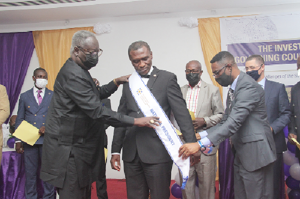 Mr Ben Owusu-Mensah (left), Board Chairman, Chamber of Shipping and a Fellow of Chartered Institute of Logistics and Transport, with the aid of Dr Ebo Hammond, Outgoing President, Chartered Institute of Logistics and Transport, decorating Mr Mark Amoamah (middle), as the new CILT president