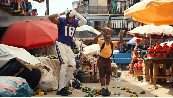 Minnesota Vikings wide receiver Justin Jefferson dances with the commercial's young star in the streets of Accra