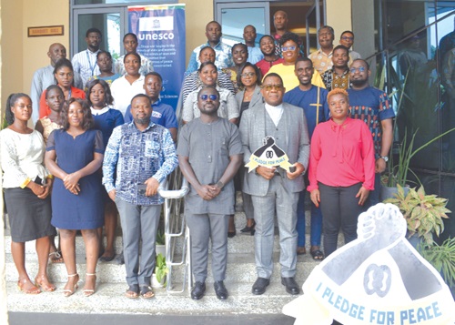  Edmond Moukala (2nd from right),  UNESCO Representative to Ghana holding “I Pledge for Peace” sign with participants after addressing the closing ceremony of the training programme