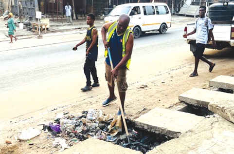 Alhaji Ibrahim Sulley, Presiding Member of the assembly, desilting a choked gutter during the clean-up exercise