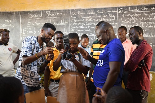 Buta explaining how the camera works to the children