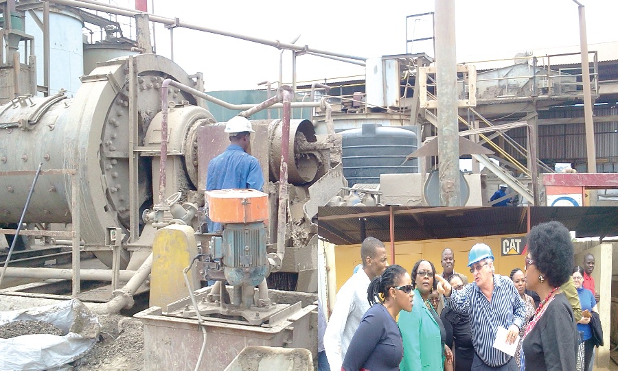 Workers on the plant that process the raw gold waste materials from the mining companies across the country. INSET: Mr R.P Smith (in helmet), CEO of the Gold Recovery Ghana Limited point to the machines as he explains the process to the SA delegation. 