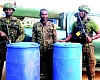 Some Ghana Immigration Service personnel with the barrels of arrested cocoa beans 